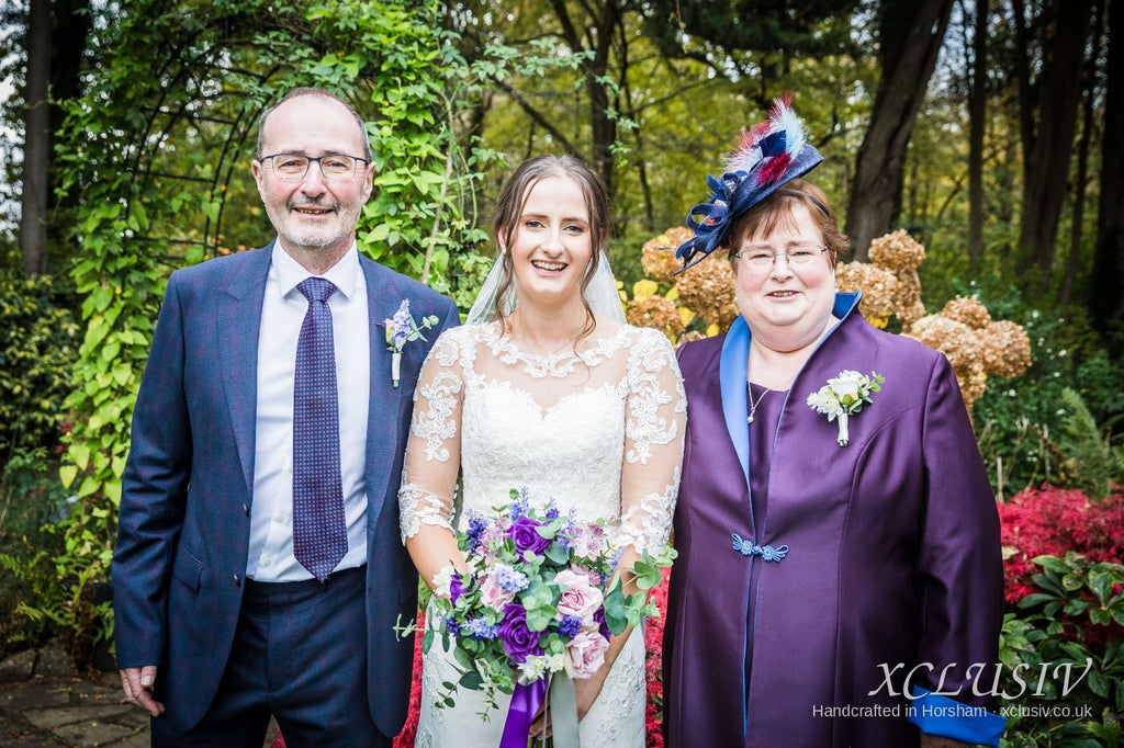 Real XCLUSIV mother of the bride in purple with the bride and groom