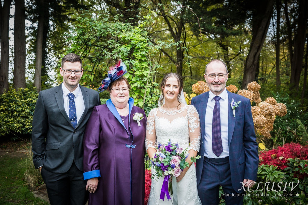 Real XCLUSIV mother of the bride in purple coat with the wedding party