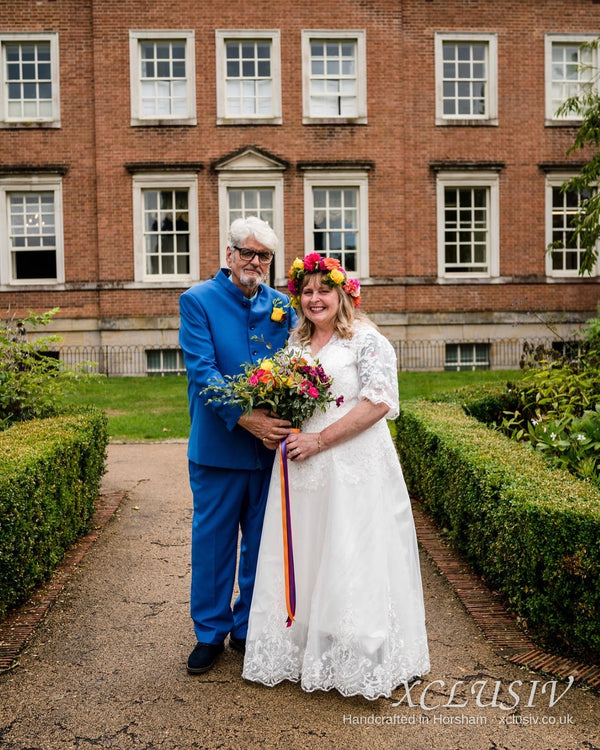 Real XCLUSIV couple: bride in ivory lace sleeved gown, groom in royal blue bespoke suit